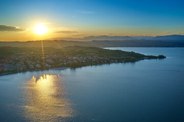 Wall Mural - Aerial view. Beautiful Garda Lake with lighthouse (Lago di Garda). View from city of Desenzano del Garda, Italy, on sunny summer day. Natural background. Drone view of Desenzano del Garda.