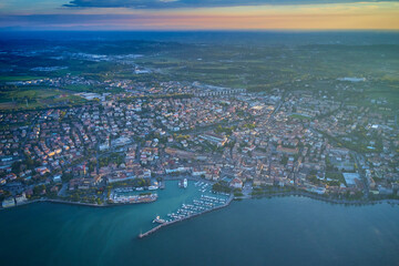 Wall Mural - Aerial view. Beautiful Garda Lake with lighthouse (Lago di Garda). View from city of Desenzano del Garda, Italy, on sunny summer day. Natural background. Drone view of Desenzano del Garda.