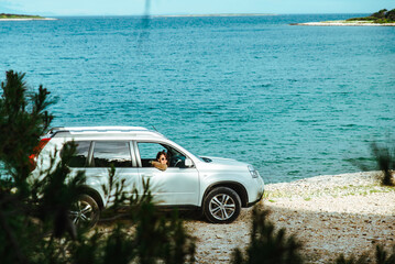 Wall Mural - woman in white suv car at sea beach. bay on background