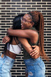 © Raul Mellado - young black women laughing and hugging each other