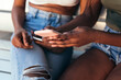 © Raul Mellado - hands of black woman showing her phone to a friend