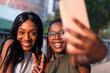 © Raul Mellado - two funny young women smiling while taking selfie
