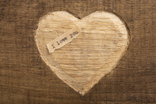 I Love You - Tiny Typed Text Note Close Up. Valentines Day Greetings Concept. Carved Heart Shape On Wood As Background For Valentines Greeting Card.