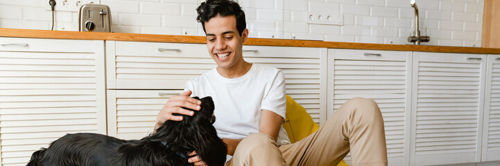 Sticker - Smiling hispanic young man petting his dog