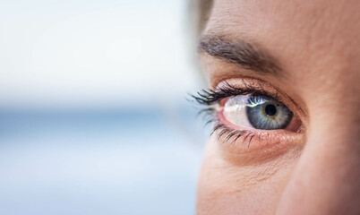 Beautiful close up shot of a blue-green eye of an unrecognizable young woman