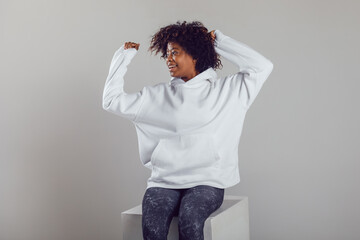 African american woman with puffy hair in a white hoodie on a white background. Mock-up.