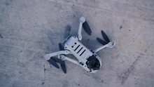 Crashed Drone On A Gray Background With A Broken Camera