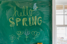 Hello Spring Written On Chalkboard At Home