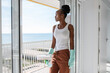 © Milles Studio/Stocksy - Black housewife admiring sea after window washing