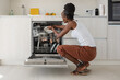 © Milles Studio/Stocksy - Black housewife putting dishware in dishwasher