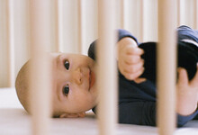 Baby Smiles In His Crib. Shot On 35 Mm Film