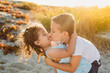 © Kelsey Smith/Stocksy - Young brother kissing sister at beach
