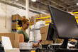 © Raymond Forbes LLC/Stocksy - E-Commerce employee packs box for shipping