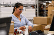 © Raymond Forbes LLC/Stocksy - Employee prepping shipping label at  warehouse