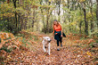 © Daniel Gonzalez/Stocksy - A beautiful woman has fun with her dog in autumn