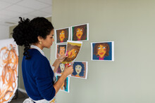 Woman Decorating Walls With Illustrated Portraits