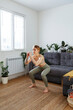 © Danil Nevsky/Stocksy - Sportive woman practicing squat at home