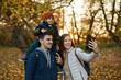 © Boris Jovanovic/Stocksy - Family Taking A Selfie In A Park