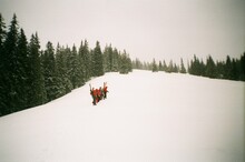 Hikers Climbing Up Snowy Hill