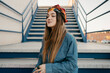 © Eloisa Ramos/Stocksy - Cheerful student woman outside on stairs