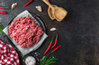 Raw minced beef meat on a tray over black background.