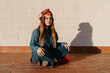 © Eloisa Ramos/Stocksy - Woman with cuban style sitting on the rooftop floor