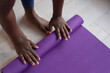 © Anna Berkut/Stocksy - yoga mat and female hands close up