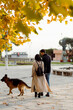 © Mauro Grigollo/Stocksy - A couple walks the dog in town