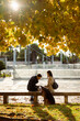 © Mauro Grigollo/Stocksy - Couple sitting on a bench in the fall season
