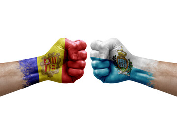 Two hands punch to each others on white background. Country flags painted fists, conflict crisis concept between andorra and san marino