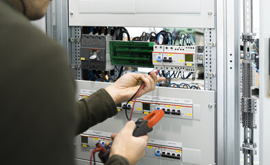 Wall Mural - electrician measuring voltage with a digital multimeter