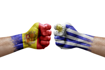 Two hands punch to each others on white background. Country flags painted fists, conflict crisis concept between andorra and uruguay