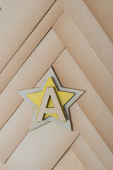 the letter A on two wooden stars (one yellow) on old, faded paper 