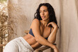 © Anna Tabakova/Stocksy - Woman in cozy sweatpants and sport bra smiling