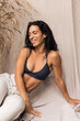Woman in cozy sweatpants and sport bra smiling