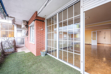 Terrace with similar artificial grass floor and white aluminum barred doors with crystals