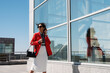 © Milles Studio/Stocksy - Businesswoman with smartphone walking in sunny downtown