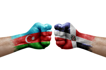 Two hands punch to each others on white background. Country flags painted fists, conflict crisis concept between azerbaijan and dominican republic