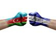 Two hands punch to each others on white background. Country flags painted fists, conflict crisis concept between azerbaijan and honduras