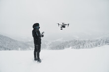 Drone Pilot Filming On Snowy Mountain 