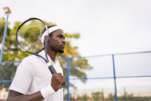 Concentrated Black Player Holding A Tennis Racket