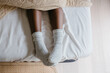 © Jodie Johnson Photography/Stocksy - Feet with socks at the end of a bed from above
