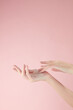 © Tuan  Nguyen  - Hand model using cosmetic with a pink background for cosmetic advertising , front view
