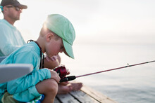 Boy And Father Fishing On A Pier