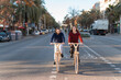 © Igor Kardasov/Stocksy - Content young couple riding eco bicycles on road