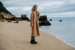 © Olga Moreira/Stocksy - Full body portrait of a woman on winter beach