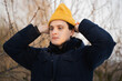 © Olga Kozicka/Stocksy - Man Putting On Winter Hat