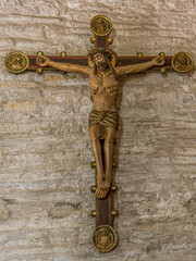 Wall Mural - an old colored crucifix from the 15th century on a stone wall