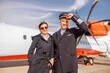 © Kostiantyn - Joyful male pilot and stewardess standing arm in arm at airport