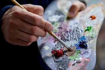 Adult man painter painting on canvas background